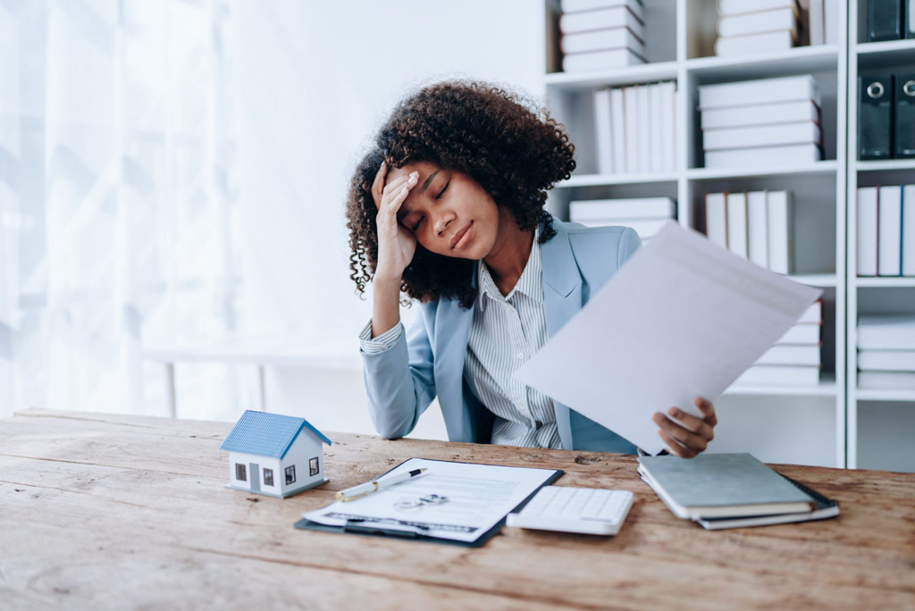 Homebuyer pausing before signing a purchase agreement, reflecting uncertainty about moving forward with a home offer